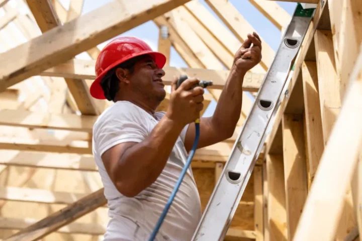 A man on a ladder with a drill