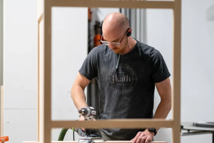 Team member from JKath working o a wood frame